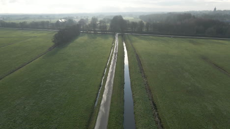 aerial of cyclists on a small road in rural holland
