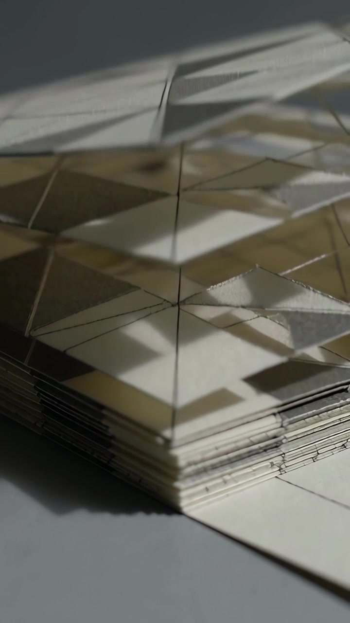 Vertical video: Moving camera revealing paper model on studio table, showing edges, triangular grid