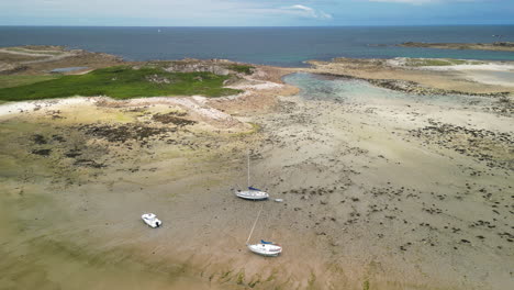 antena de dolly hacia adelante de barcos que descansan en la arena en la marea baja