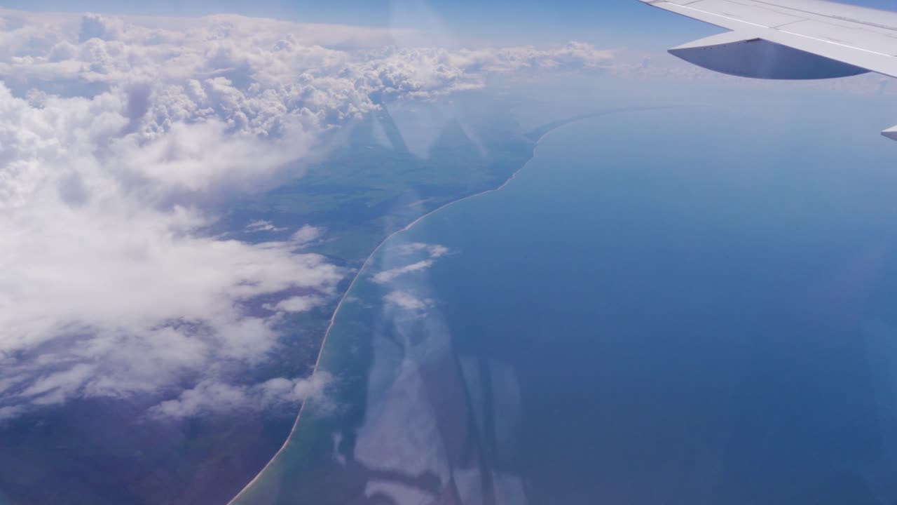 Flying Over the Baltic Sea with the Curonian Spit visible through an Airplane Window