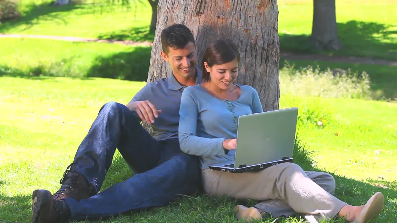 una joven pareja navegando en su computadora portátil