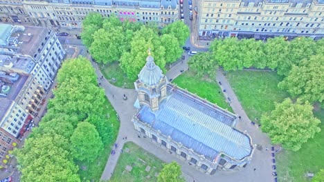 aerial footage directly above st. philip’s cathedral and the lush lawns of pigeon park, birmingham, shows historic architecture framed by city streets and greenery during a slow drone descent