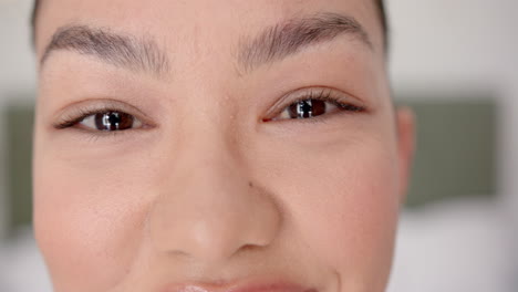 close-up of a young biracial woman''s face, showcasing her brown eyes and freckles