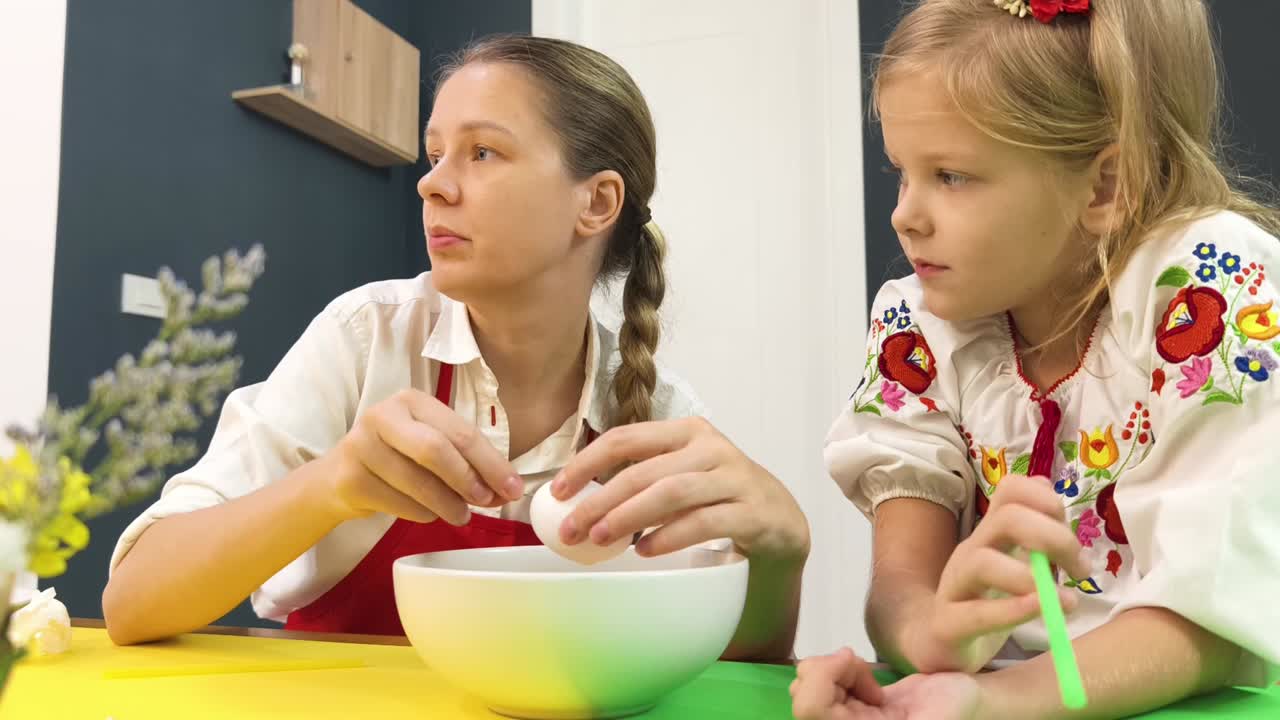 Madre e figlia che tingono le uova di Pasqua
