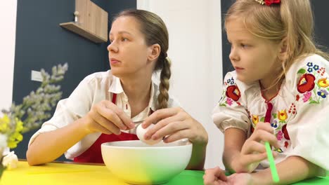 madre e hija pintando huevos de pascua