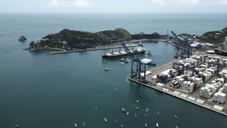 Aerial-View-of-Cargo-Ship,-Cranes-and-Containers-in-Port-of-Santa-Marta-Colombia-on-Cloudy-Day,-Drone-Shot