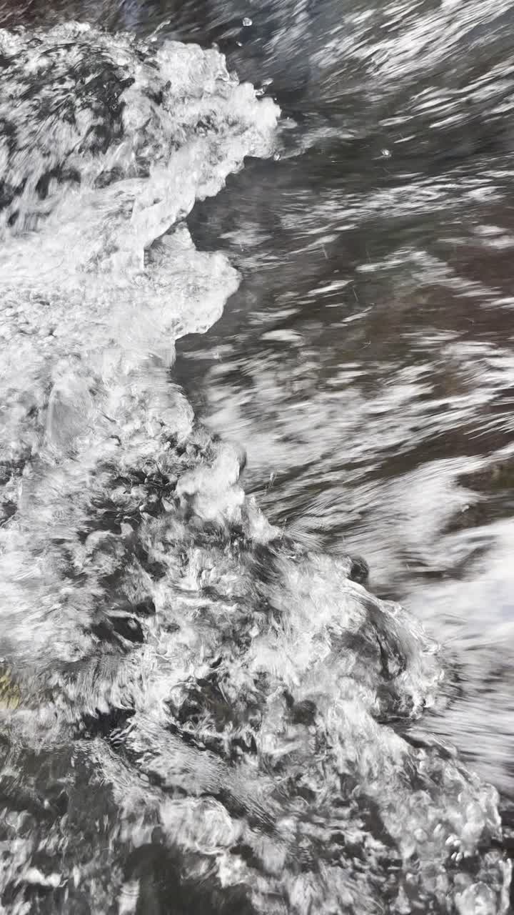 Primo piano di acqua impetuosa con schiuma e bolle
