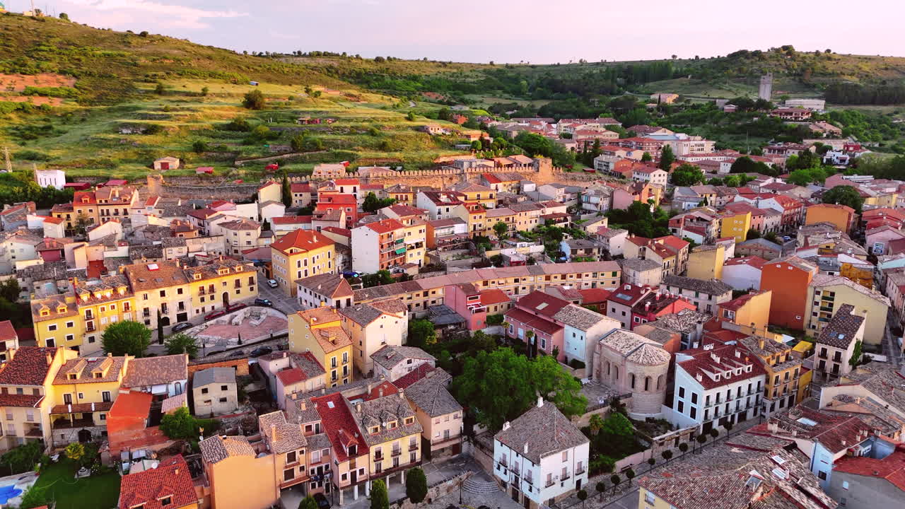 Drone flies forward above the rooftops of Brihuega, La Alcarria, Spain. The clip reveals traditional houses, medieval walls, narrow streets, and warm morning light over the historic Spanish village