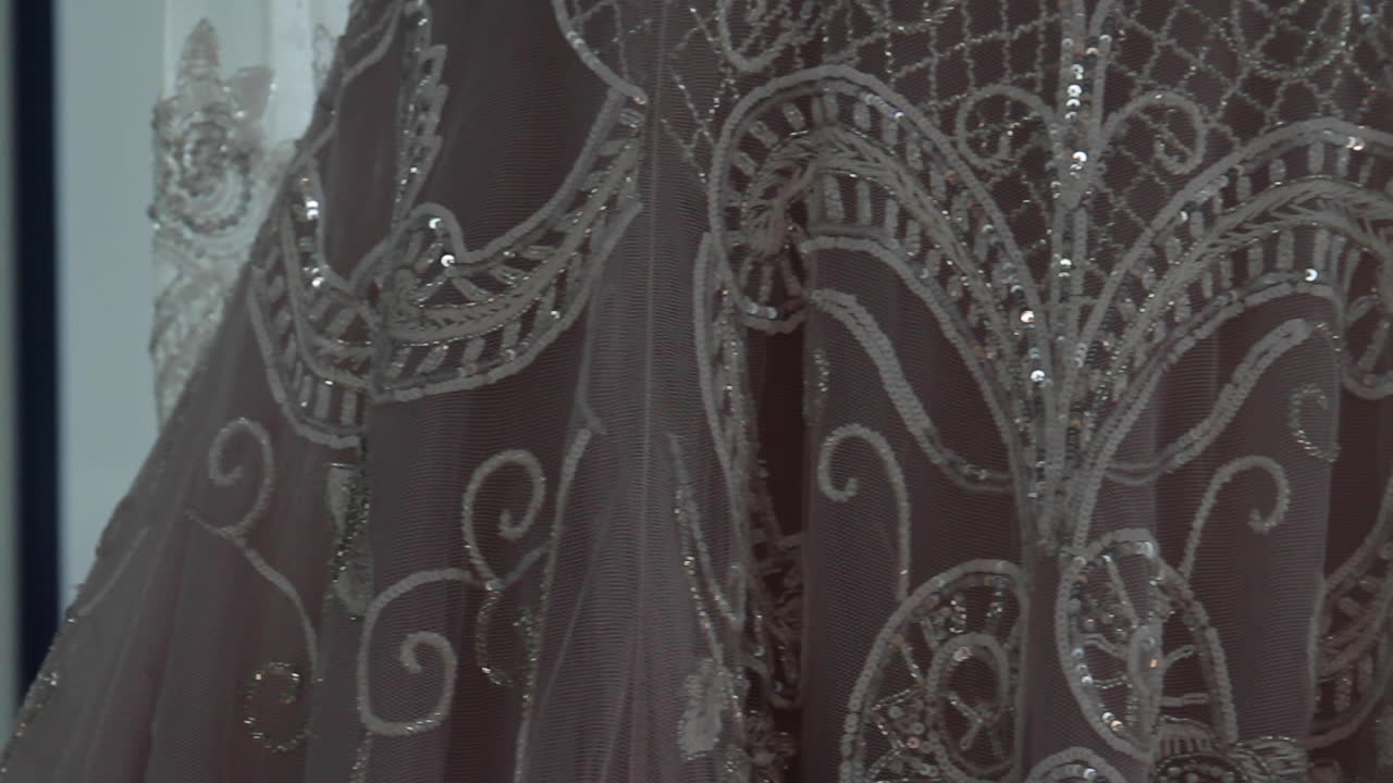 vestido de novia colgado cerca de una ventana brillante en el lugar de la boda