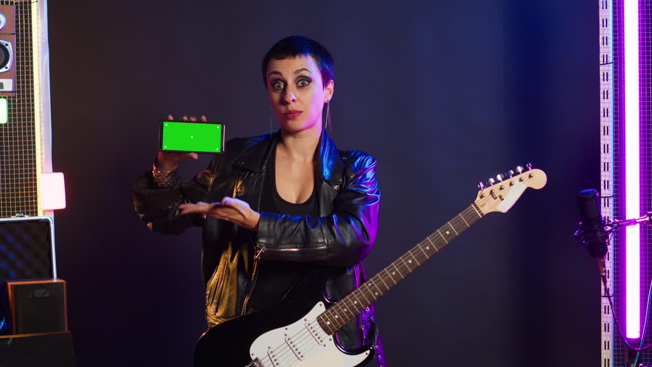 Woman with Guitar and Green Screen Cell Phone