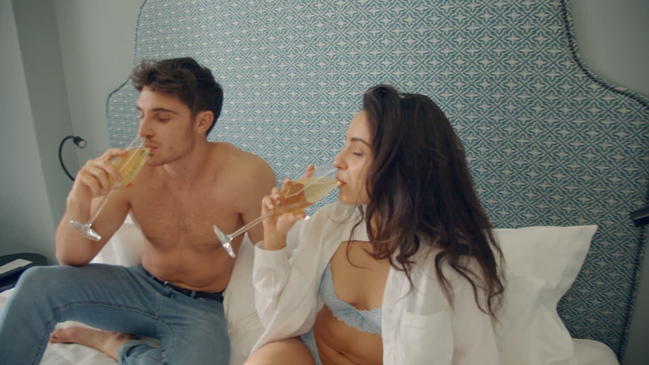 una pareja tocando copas en un apartamento de lujo, una pareja disfrutando de un fin de semana romántico.