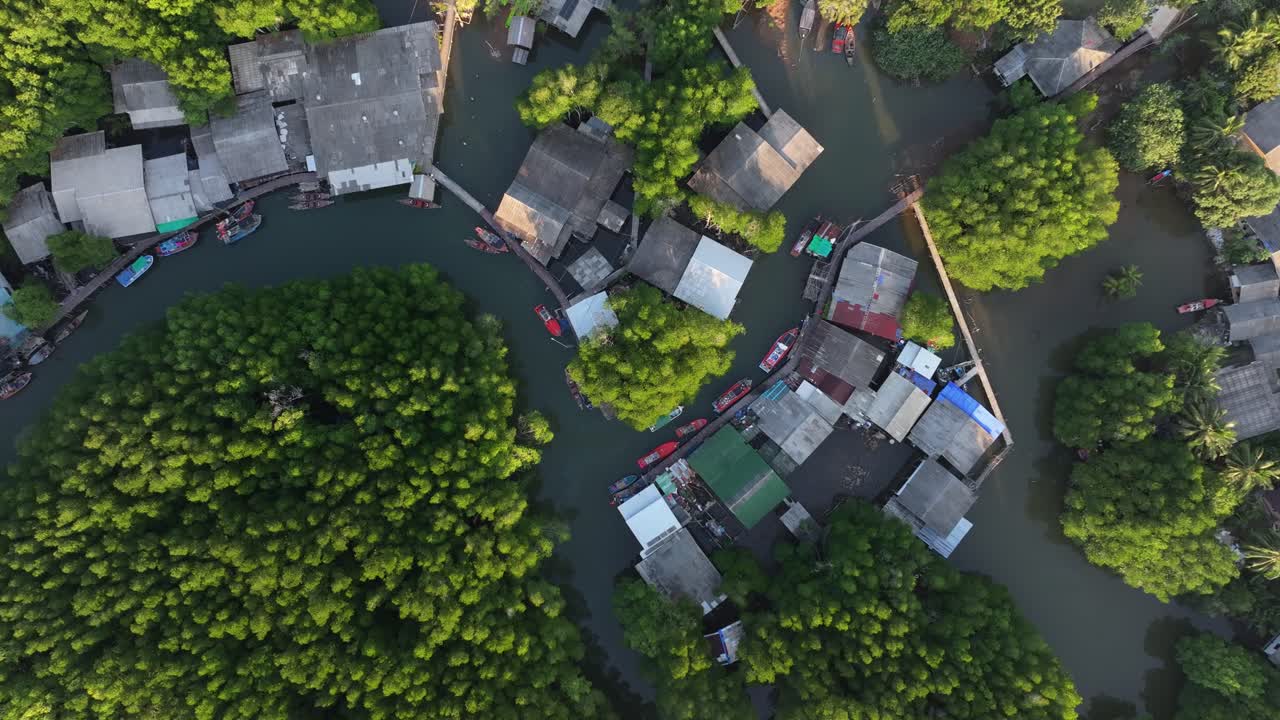 ภาพมุมสูงจากโดรนยามเย็นของหมู่บ้านริมแม่น้ำและเรือในป่า ที่เกาะช้าง ประเทศไทย