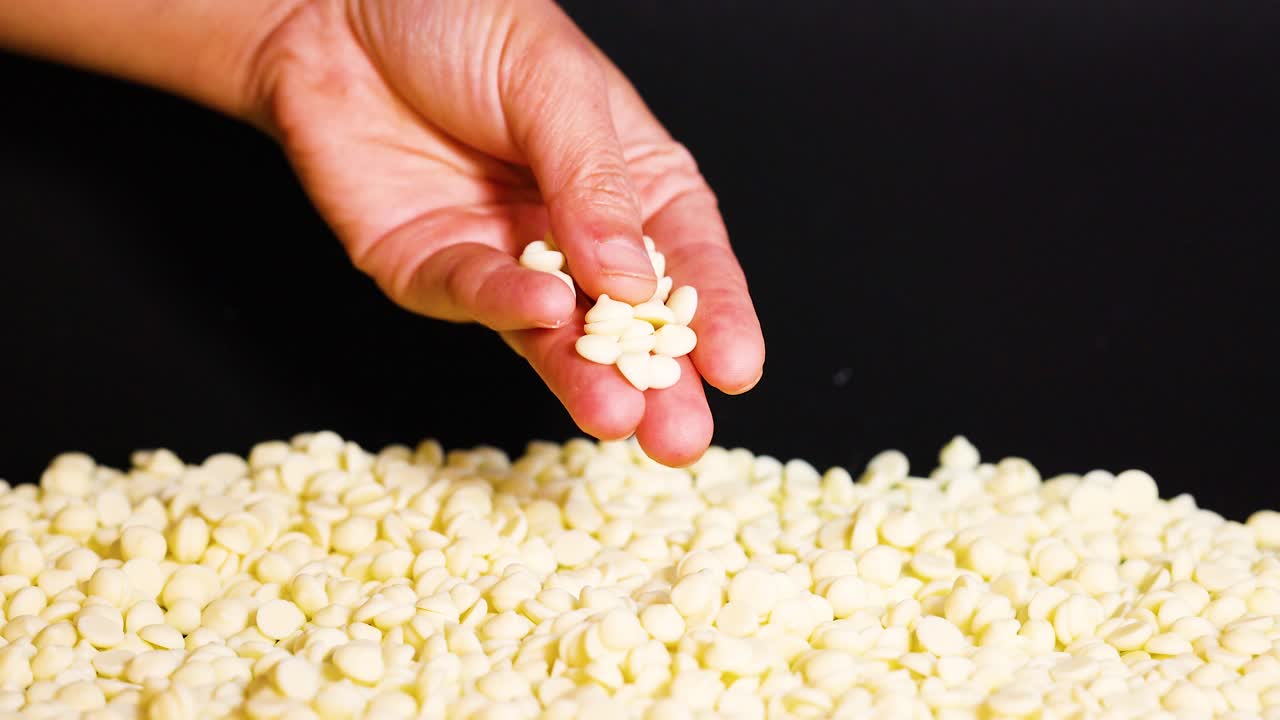 recogiendo a mano trozos de chocolate blanco de la pila