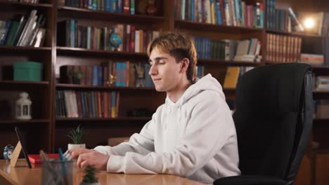 el tipo está sentado en una mesa, inicialmente involucrado en una conversación con alguien, aunque la otra persona no es visible