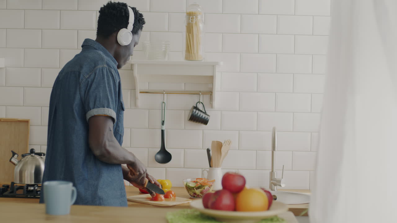 Uomo che cucina e si gode la musica in cucina