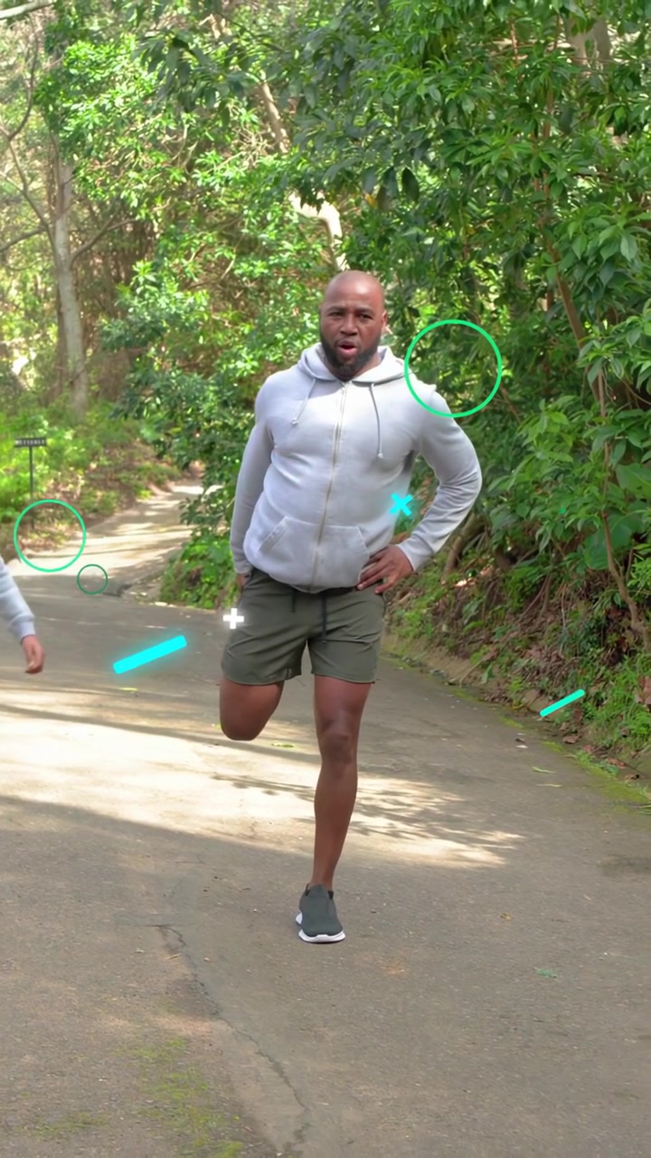 Video verticale: Uomo che segue il lancio di un bambino, mantenendo l'equilibrio, facendo jogging mentre la grafica si sovrappone al ginocchio