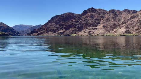una foto de las montañas de el dorado inclinándose desde el río colorado en un día soleado