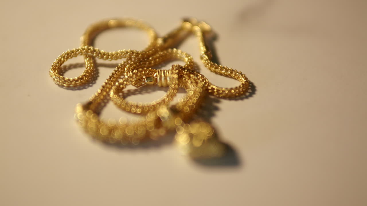 왼쪽 상단에서 오른쪽 하단으로 내려가 황금색 목걸이와 심장 모양의 목걸이를 보여주는 프레임