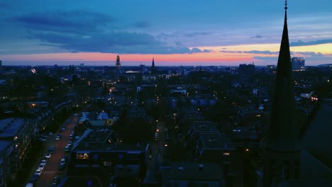 Descending-crane-down-on-Arnhem-Dutch-city-skyline-during-sunrise-with-church