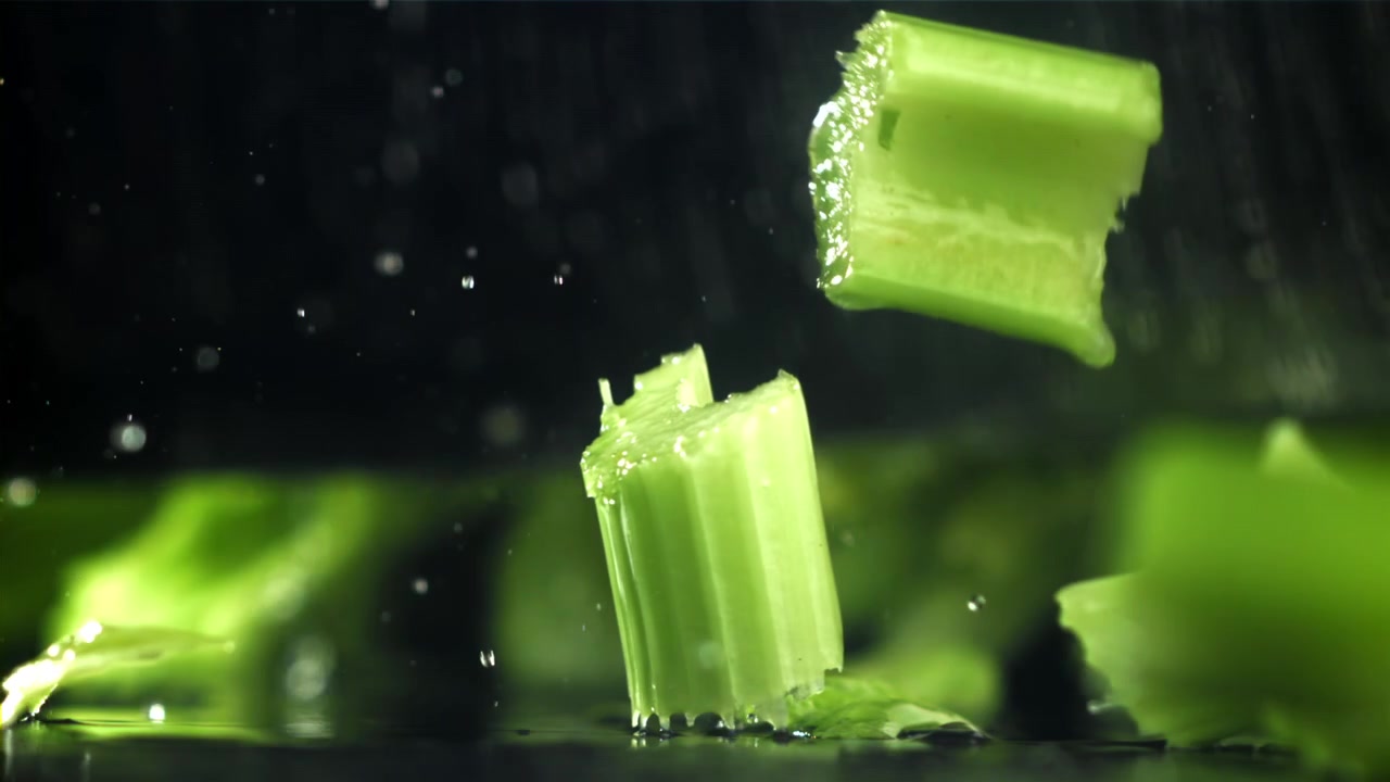 Slow Motion of Fresh Celery Pieces Dropping into Water