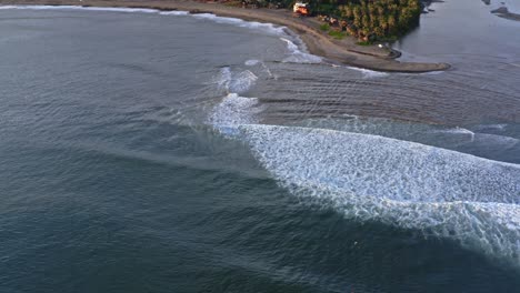 hermosas olas rodando y estrellándose en la playa, revelación aérea de arriba hacia abajo