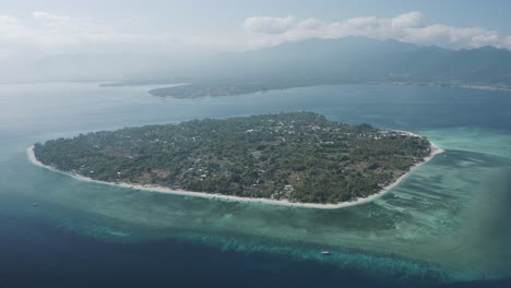 Toma-Aérea-De-Una-Isla-Aislada-Cubierta-De-árboles-En-Tailandia-Con-Paisaje-Marino-Y-Cadena-Montañosa-Al-Fondo-Durante-El-Día