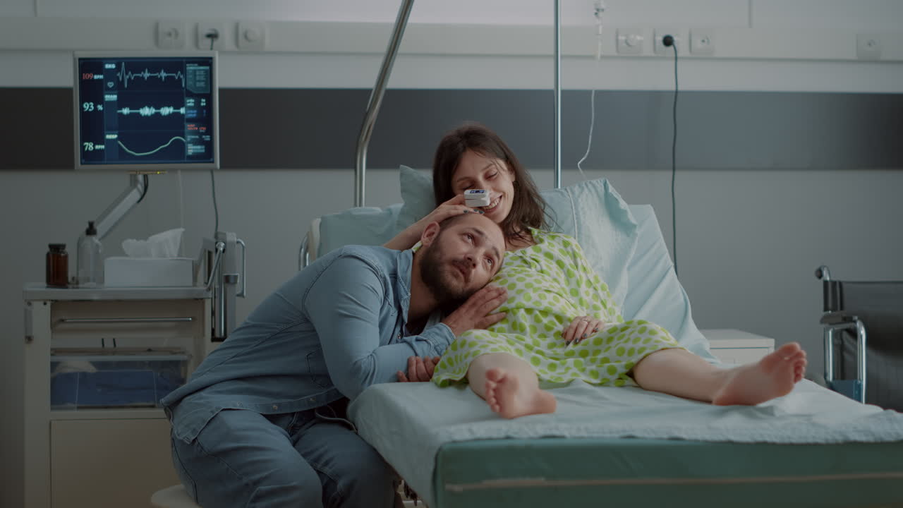Caucasian man and woman expecting child in hospital ward