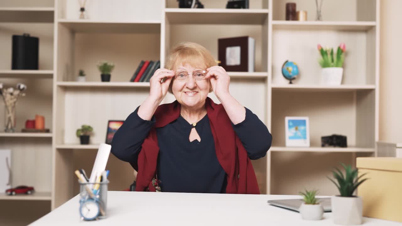 mujer mayor felizmente se pone sus gafas y mira a la cámara