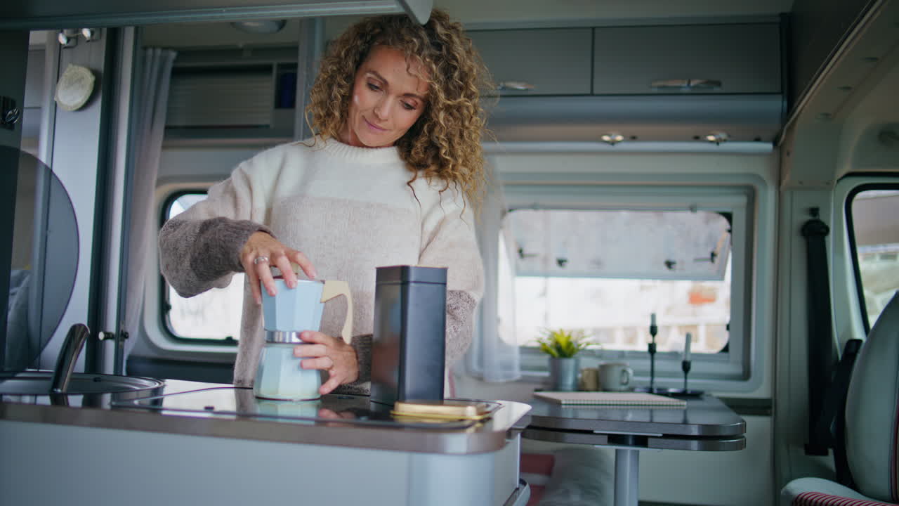 mujer relajada haciendo café en la cocina del remolque. dama cocinando en la furgoneta