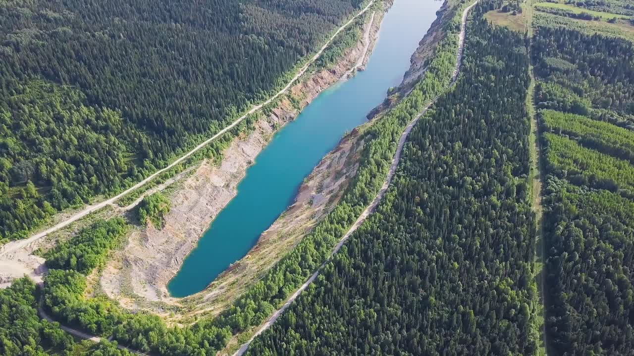 vista aérea de un lago de cantera rodeado de bosque