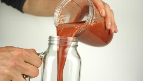 a rich red healthy smoothie is poured into a trendy kilner jar with handle