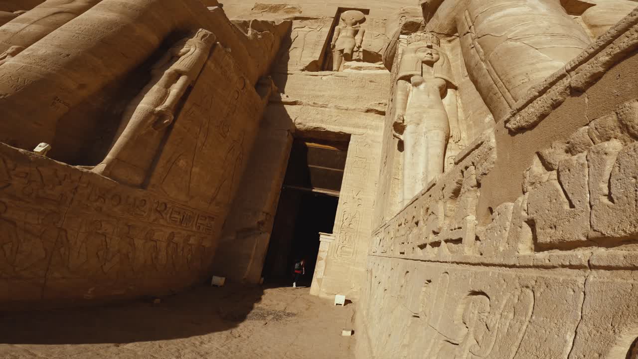 Low-angle view of the monumental entrance to Abu Simbel Temple in Egypt, showcasing massive stone statues.