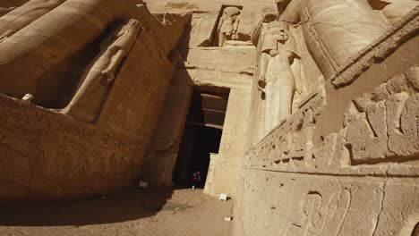low-angle view of the monumental entrance to abu simbel temple in egypt, showcasing massive stone statues.