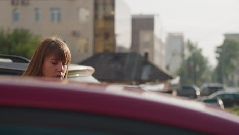 Una-Mujer-Cansada-Se-Sube-A-Un-Auto-Rojo-En-El-Asiento-Del-Conductor-Cerrando-La-Puerta