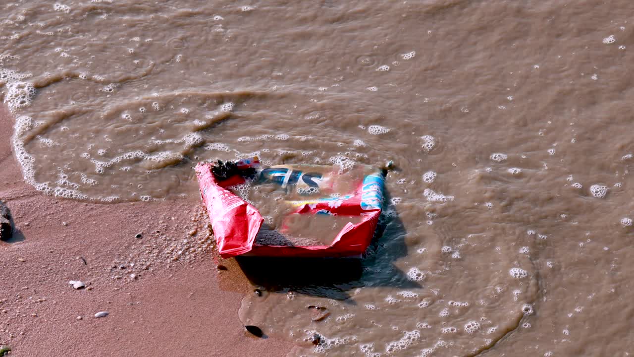 las olas del océano interactúan con la basura en la playa