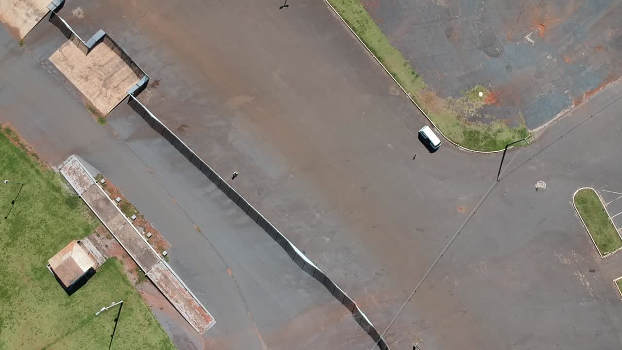 화창한 날 빈 주차장에 있는 한 대의 자동차의 하강 드론 영상