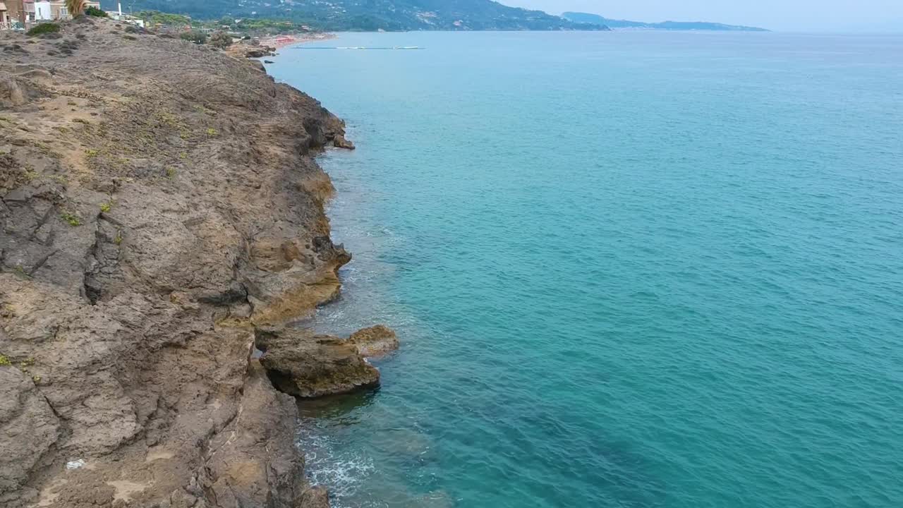 Zakynthos Greece Point St. Nicholas rocky cliffs with beautiful clear turquoise water, Aerial drone flyover down shot
