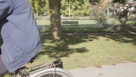 un joven en bicicleta por un carril bici en un día soleado