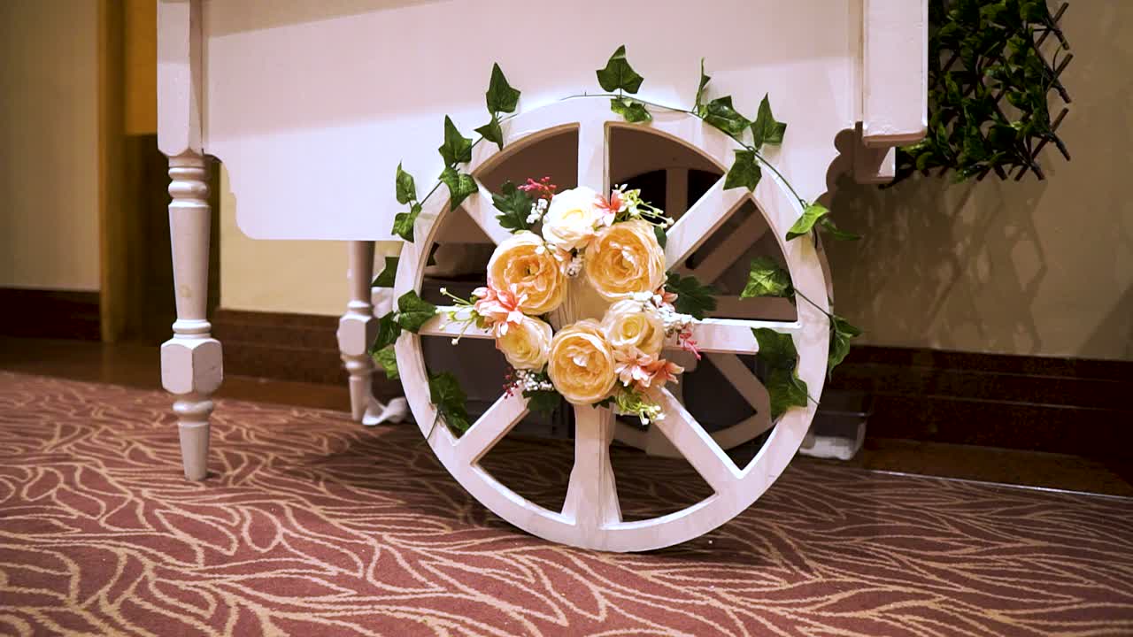 rueda de diseño artístico con flores de rosas amarillas y ruedas verdes minimalista blanco limpio pegado a la mesa lleno de postres pies de mujer caminando más cerca contratados para el evento de la boda