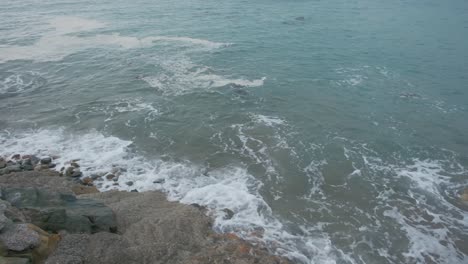 Olas-Ligeras-Del-Océano-Rompiendo-En-Una-Playa-Rocosa