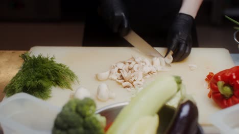 chef chopping mushrooms and vegetables