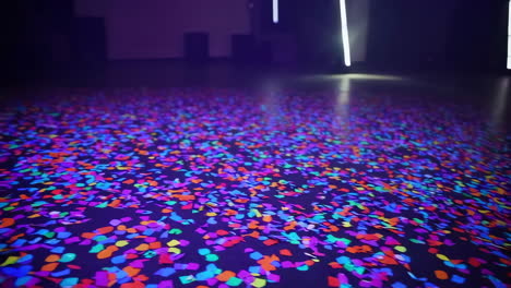 colorful confetti on a dark floor with neon lights