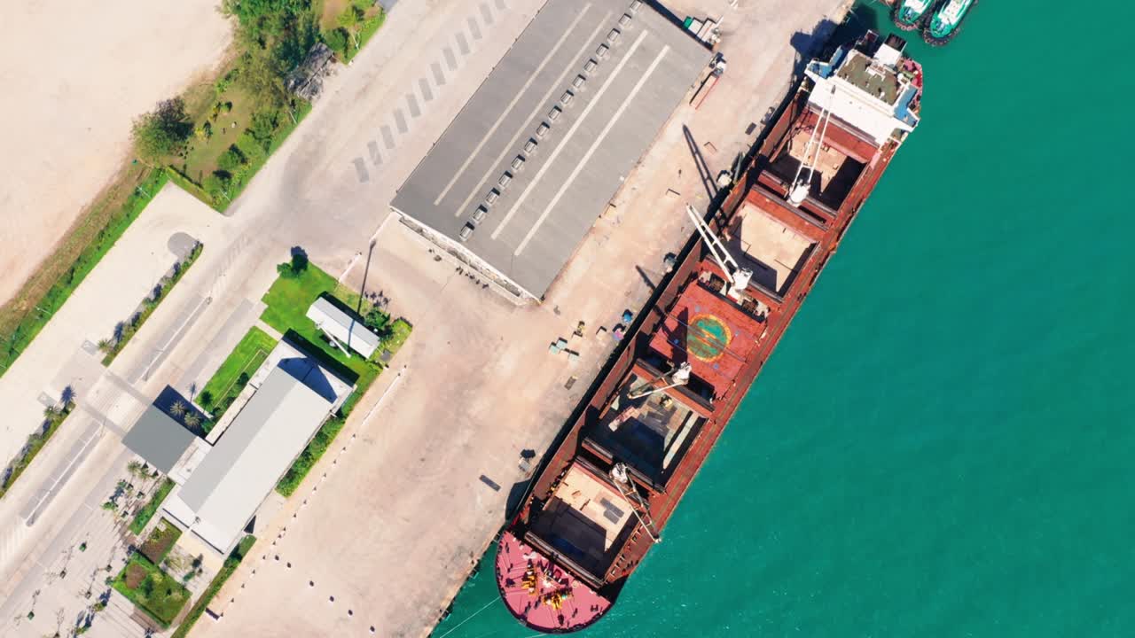 Aerial drone top view of containers cargo ship at industrial import-export port. Business logistic import and export freight transportation by container ship in open sea