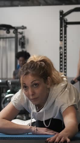 mujer estirándose en el gimnasio