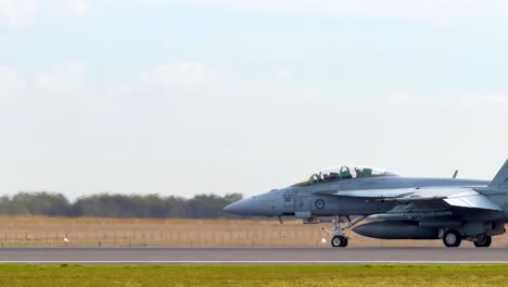 fa-18 hornet aircraft taxiing on runway at avalon airshow, geelong. clear skies, daytime, showcasing aviation technology