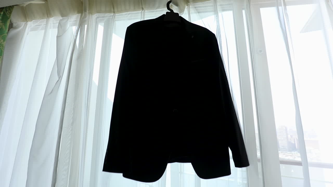 Groom's suit hanging on the window in the morning - push in