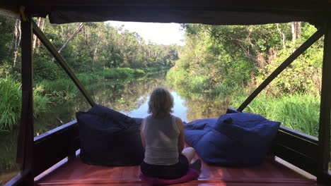 lady on boat in jungle kalimantan