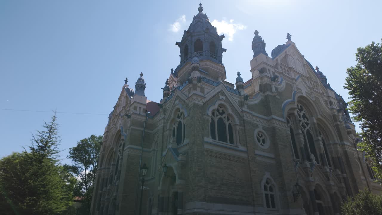 Wide-angle view of Hungary’s Szeged Synagogue with the clear sky above, capturing the landmark’s grandeur