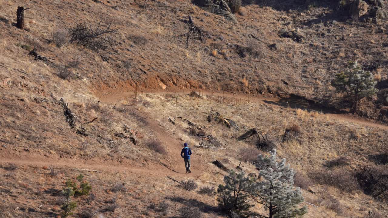 Person running in rugged trail in the Rocky Mountains