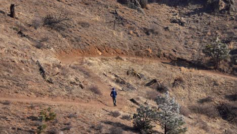 Person-running-in-rugged-trail-in-the-Rocky-Mountains